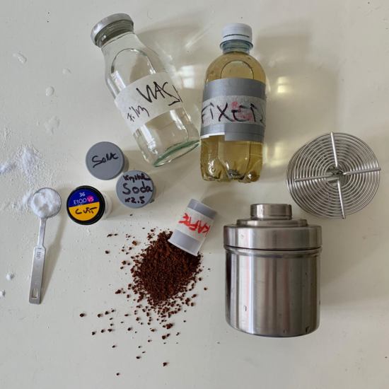 The ingredients for caffenol developing: salt, soda, coffee, fixer and wash. There is a metal cannister with a screw-on lid, and trivets that place the film inside and allow you to pull it back out with damage.