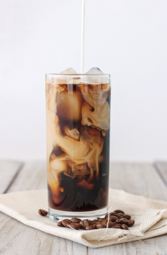 Dark chai espresso drink in a glass with ice.