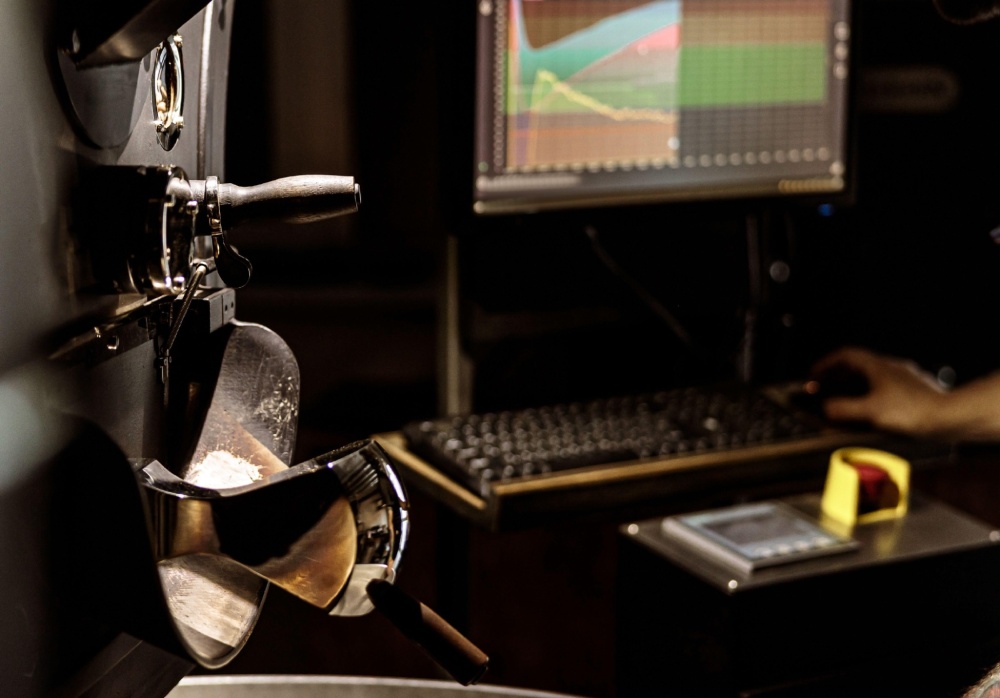 Industrial coffee roasting machine and computer monitor.