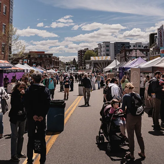 A street is closed off to make room for a market with tents and booths.
