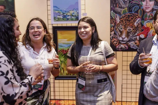 People chat in front of art at an event.