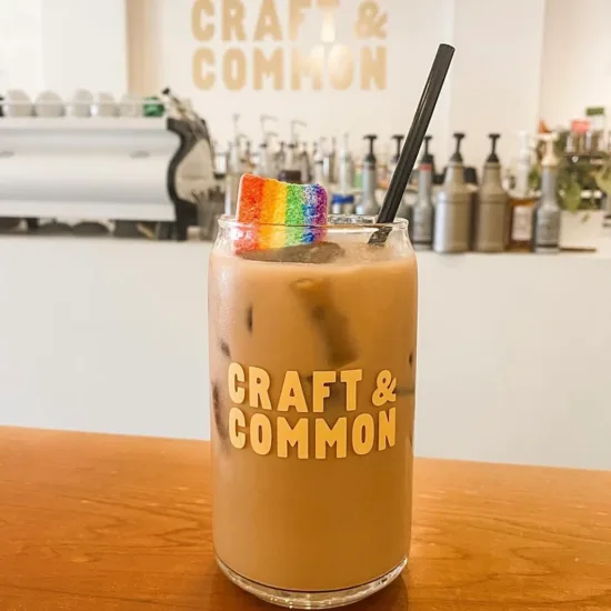Craft and Common iced latte glass with straw and a rainbow ribbon candy.