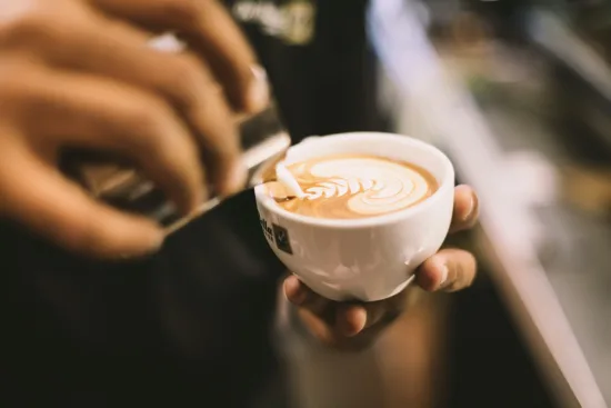 Pouring latte art into a small cup.