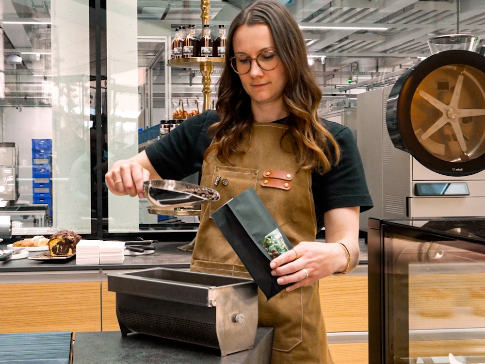 Andrea Della Zoppa, Project Manager for Thermoplan, fills a bag with roasted coffee.